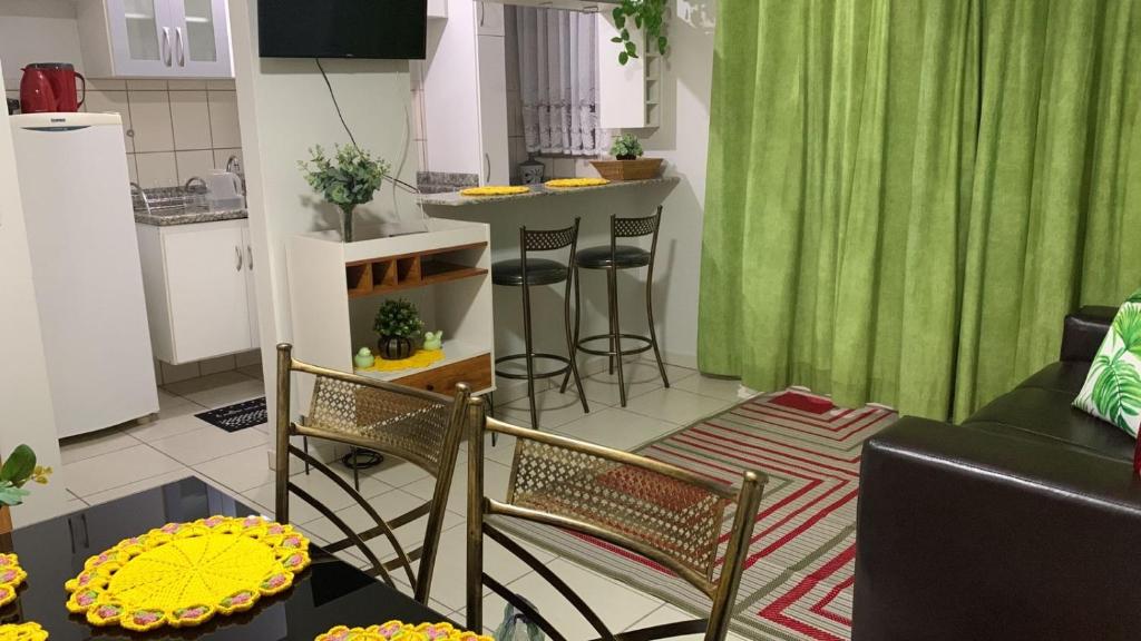 a living room with a table and chairs and a kitchen at Thermas do Bandeirante in Caldas Novas