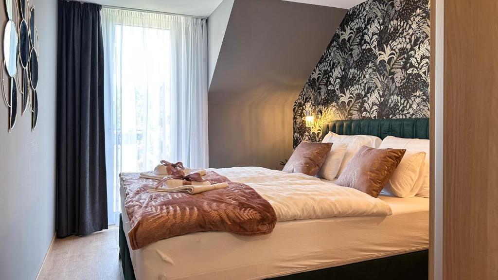 een slaapkamer met een groot bed en een groot raam bij Linden Apartman 107 - Adults Only in Mosonmagyaróvár