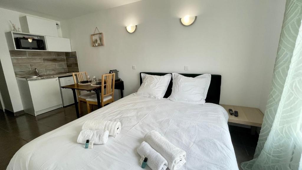 une chambre avec un lit blanc avec des serviettes dessus dans l'établissement Le Bussy - Chambre double Disney, à Bussy-Saint-Georges