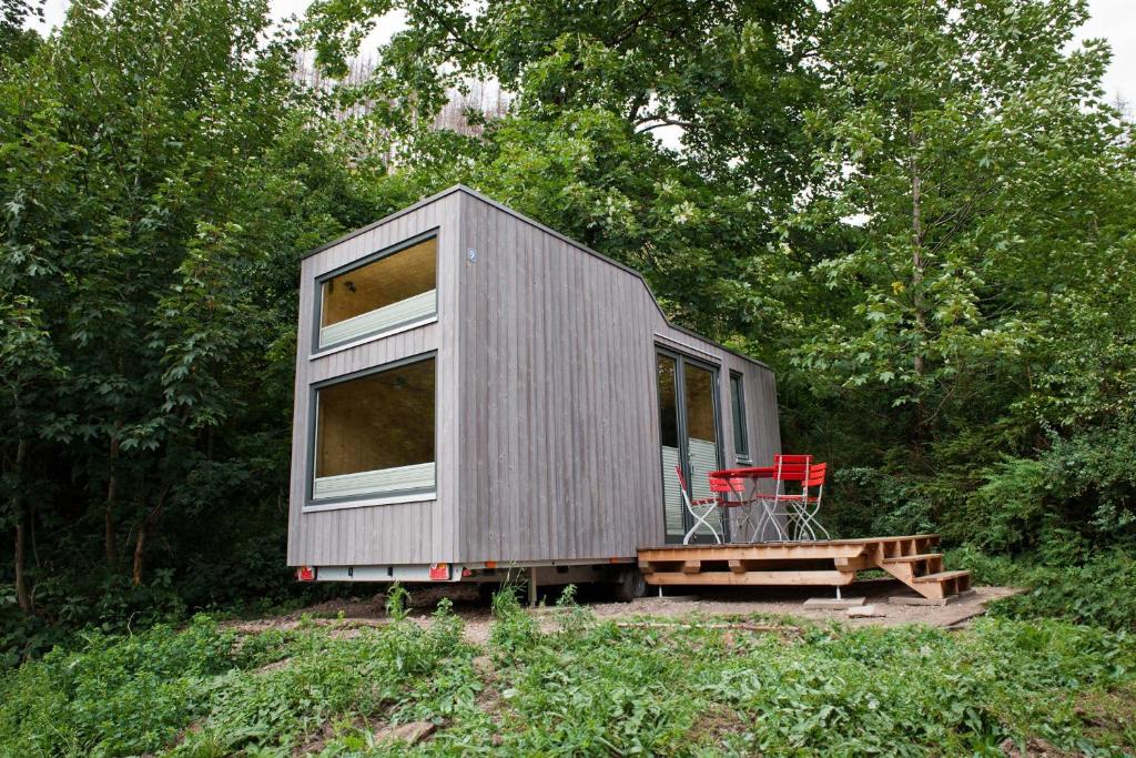 a tiny house sitting in the middle of a forest at Tiny House Nature 9 - Green Tiny Village Harz in Osterode