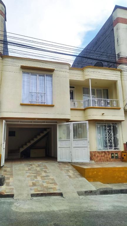 a large house with a garage and a balcony at Apartamento pinares Santa Rosa in Santa Rosa de Cabal