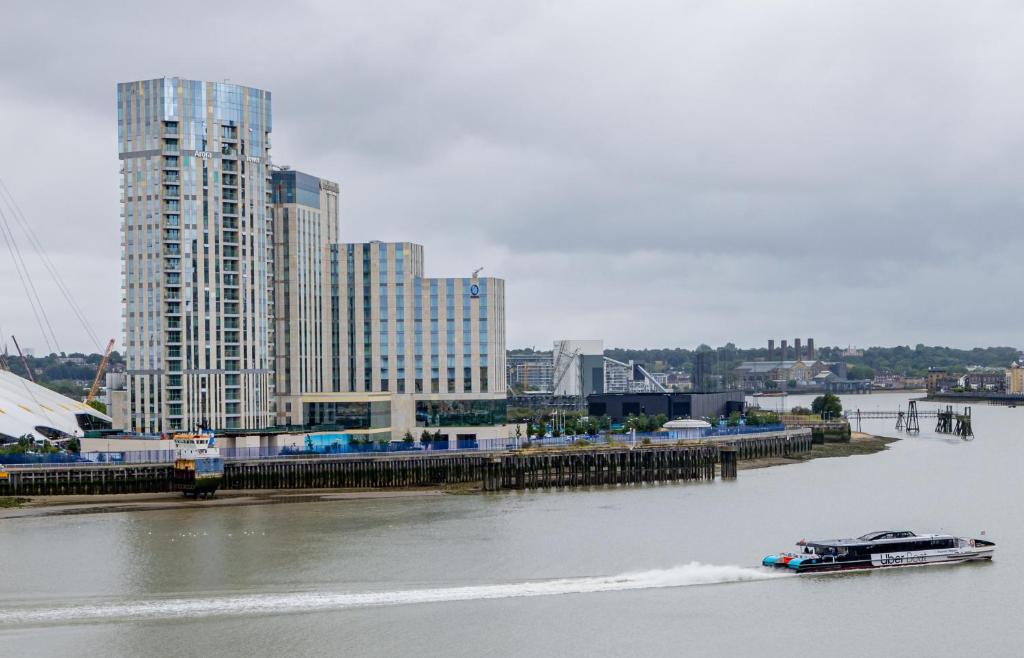 a boat in a river with buildings in the background at Nice Room Close to City231 in London