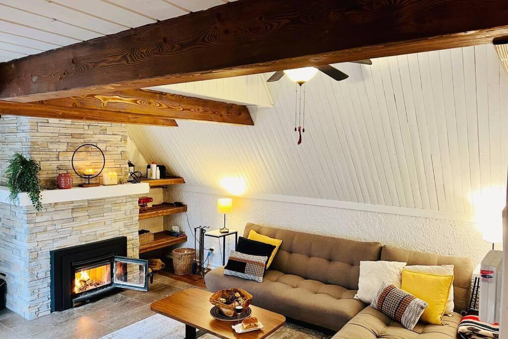 een woonkamer met een bank en een open haard bij New-ski-spa-outdoor-fireplace-Mont Orford in Orford