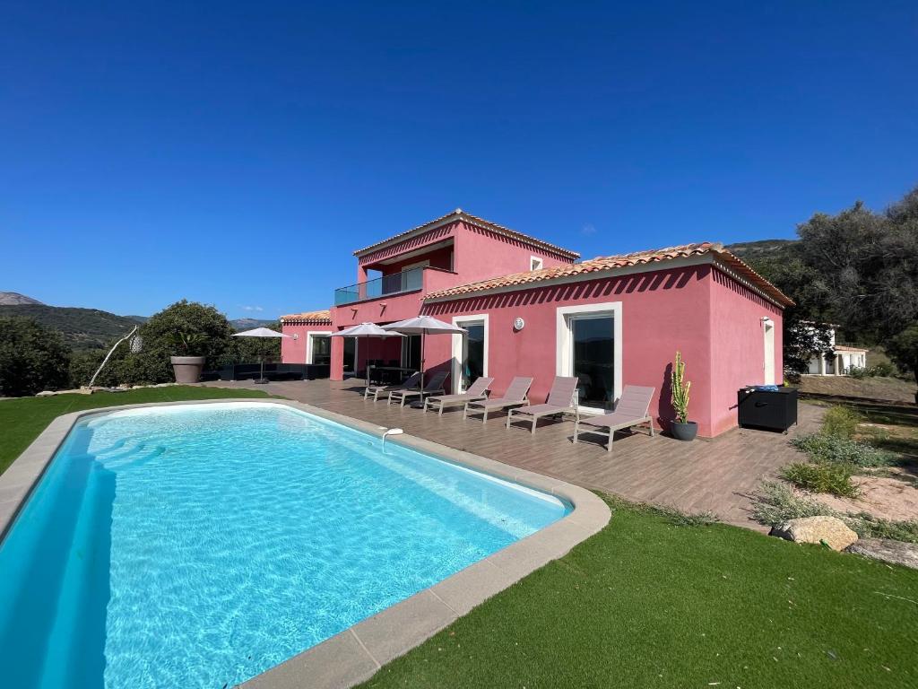 une villa avec piscine devant une maison dans l'établissement Maison Rouge, à Cargèse