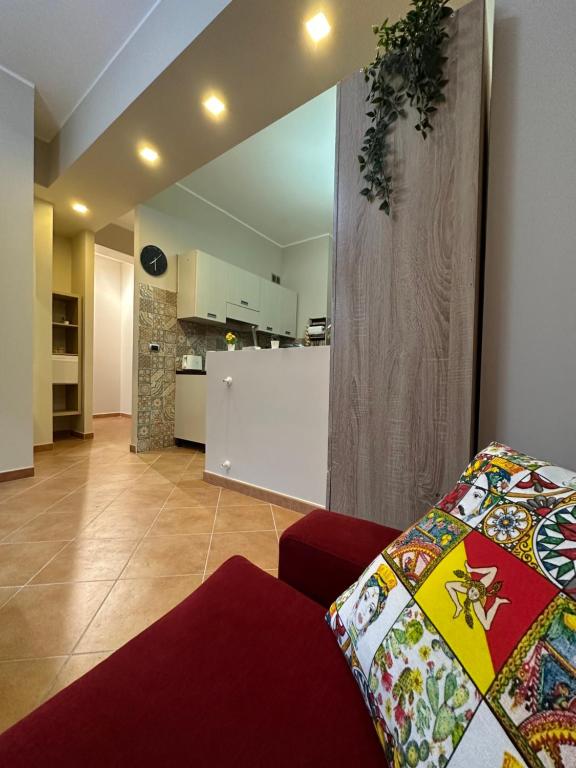 a living room with a red couch and a kitchen at Tutti i Comfort Giuliano's Apartment in Messina