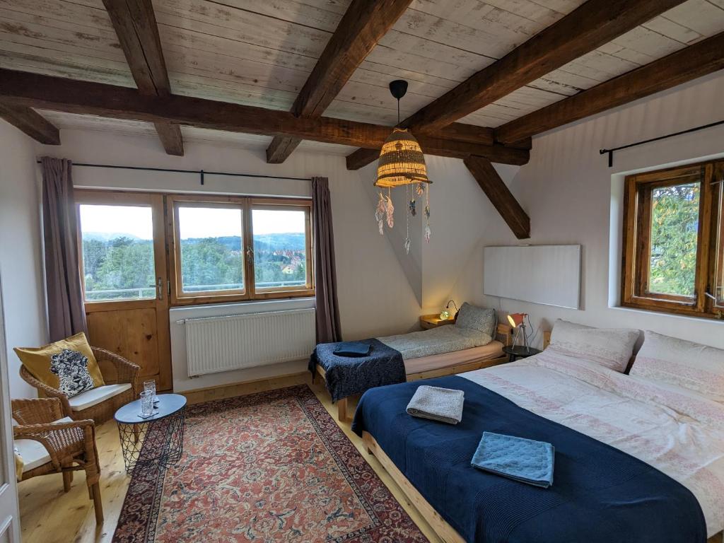 a bedroom with a bed and a couch and a table at Pod Lubogoszczem in Mszana Dolna