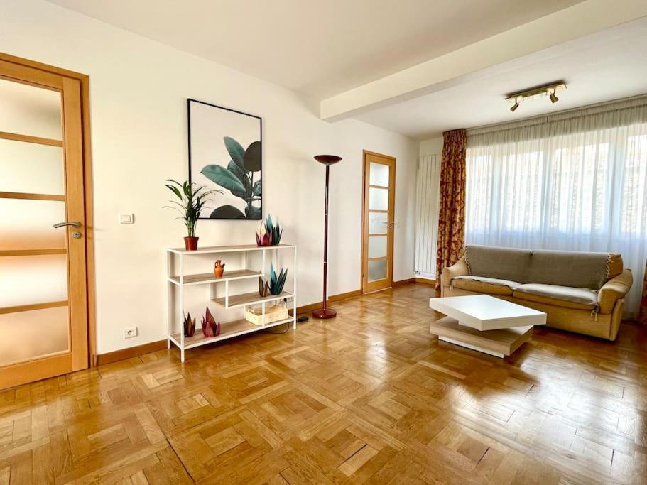 ein Wohnzimmer mit einem Sofa und einem Tisch in der Unterkunft Lumineux 2 pièces Paris nord-est in Pantin