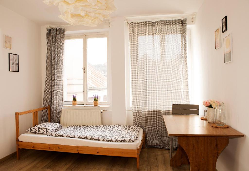 1 dormitorio con cama, escritorio y ventana en Cute 2 beds studio close to the Main Train Station, en Bratislava