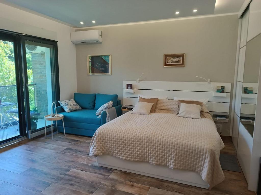 1 dormitorio con 1 cama y 1 sofá azul en Hedonica 11 Ema en Vrdnik