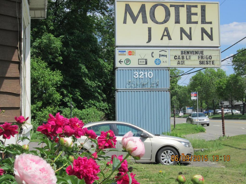 um carro estacionado em frente a uma placa de motel em Motel Jann em Cidade de Quebec