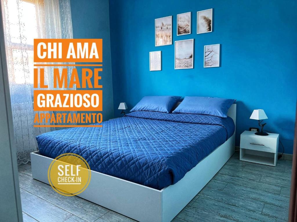 a bedroom with a bed with a blue wall at [Chi Ama il Mare] Appartamento in Latina