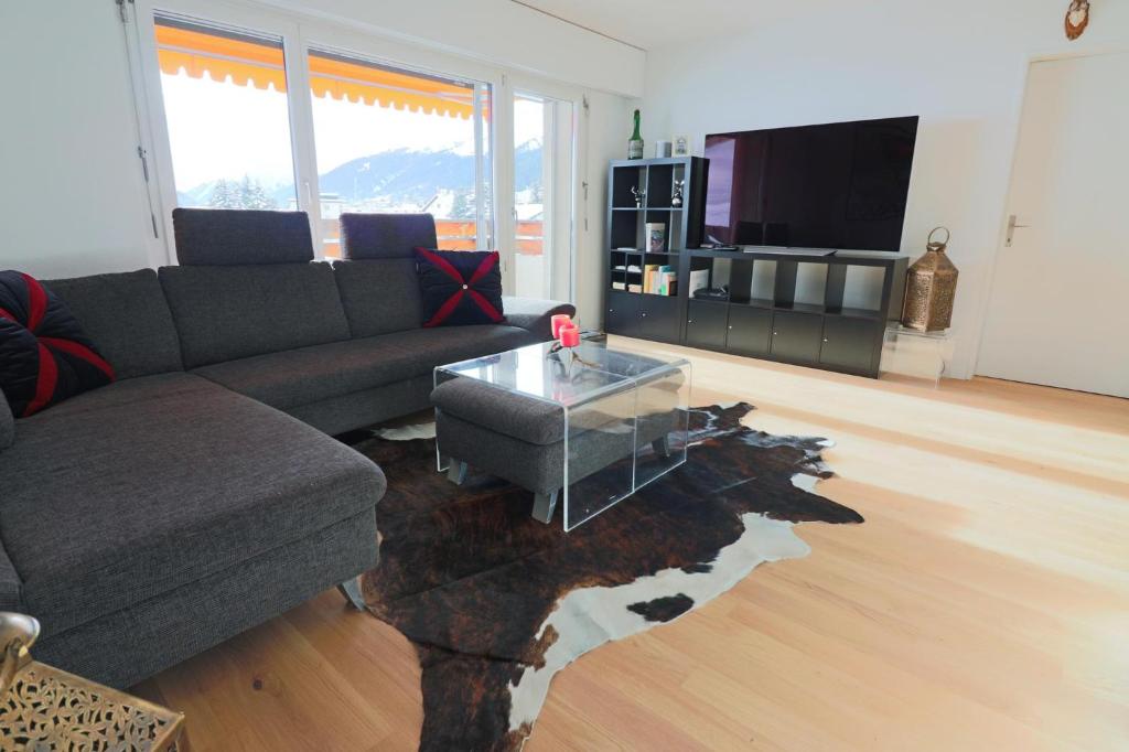 uma sala de estar com um sofá e uma mesa de vidro em Bündapark em Davos