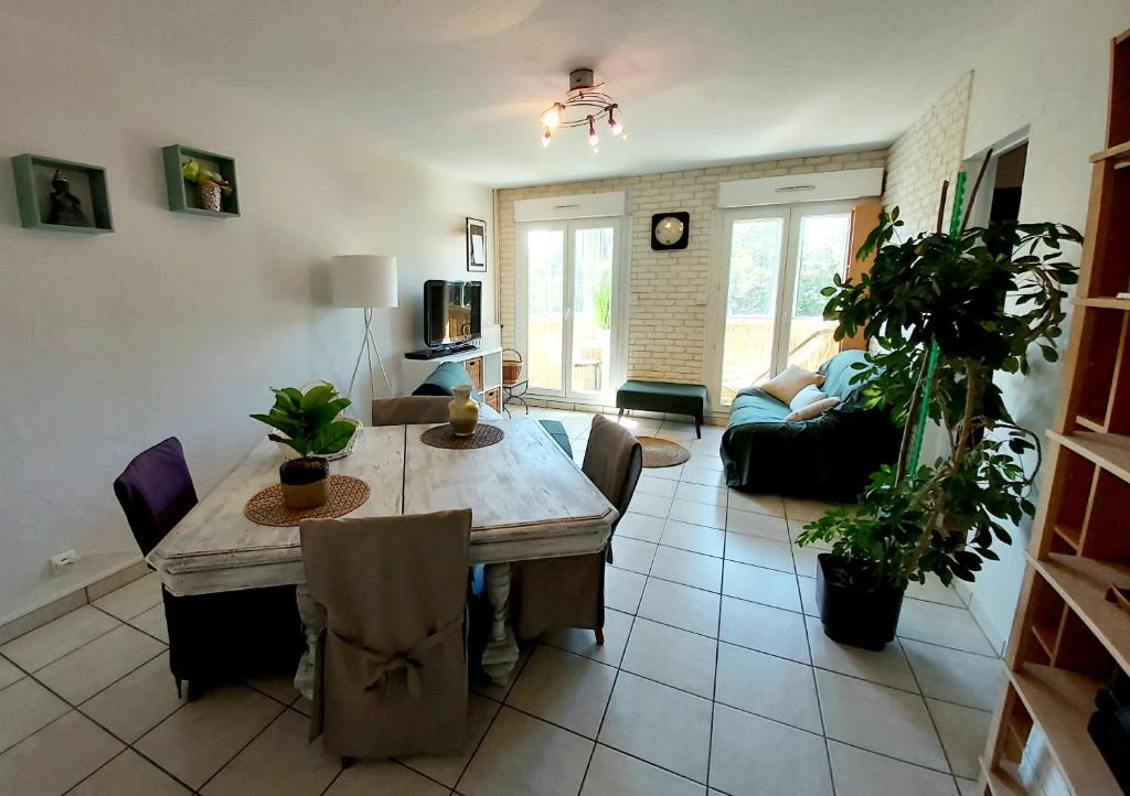 a living room with a table and a couch at :) Spacieux T4 AÉROPORT, ensoleillé, déco soignée in Blagnac