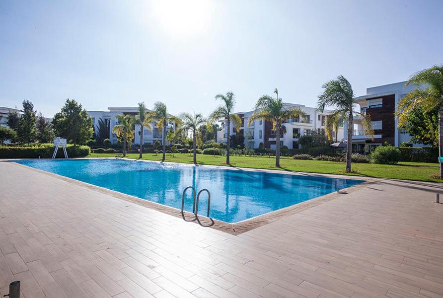 a swimming pool in the middle of a resort at Prestigia Golf city Bouskoura Apartment in Bouskoura