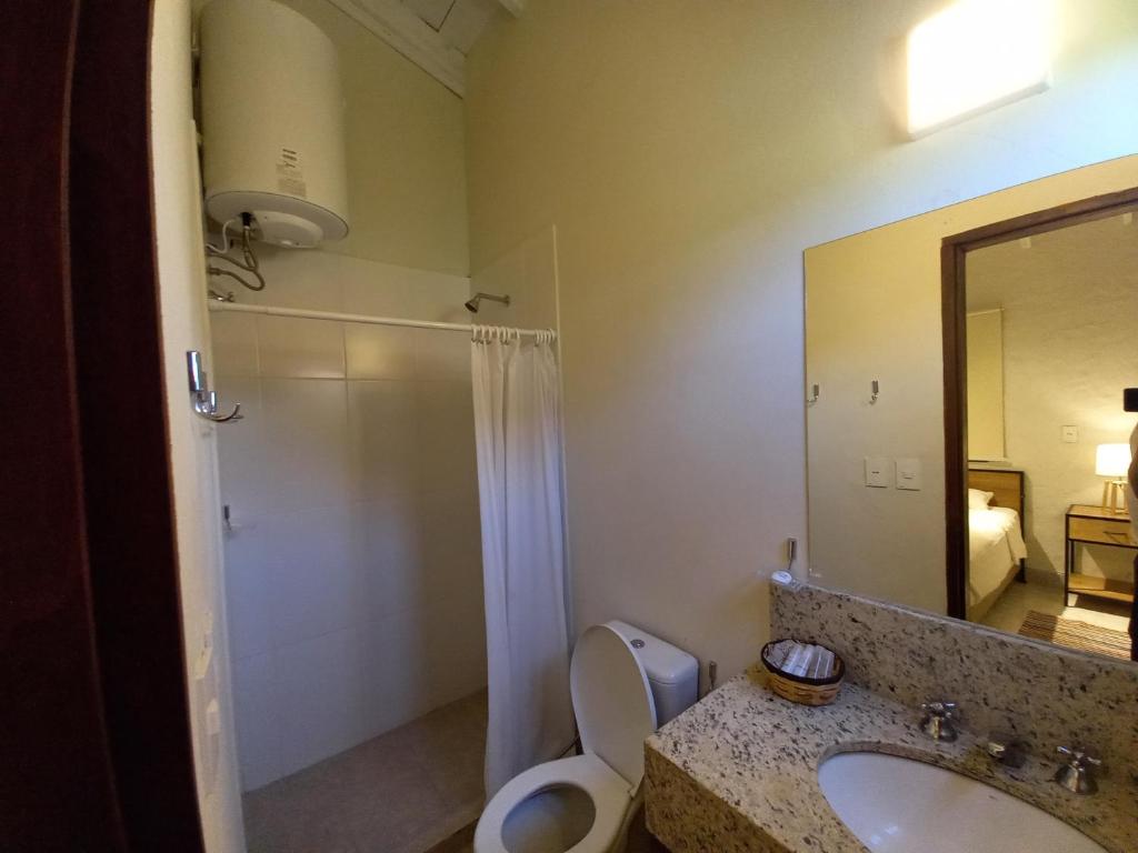a bathroom with a sink and a toilet and a mirror at La Matilde Lodge in San Bernardino