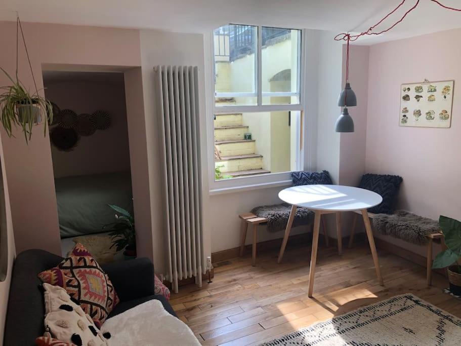 een woonkamer met een tafel en een raam bij Beautiful, well positioned flat in Clifton Wood in Bristol
