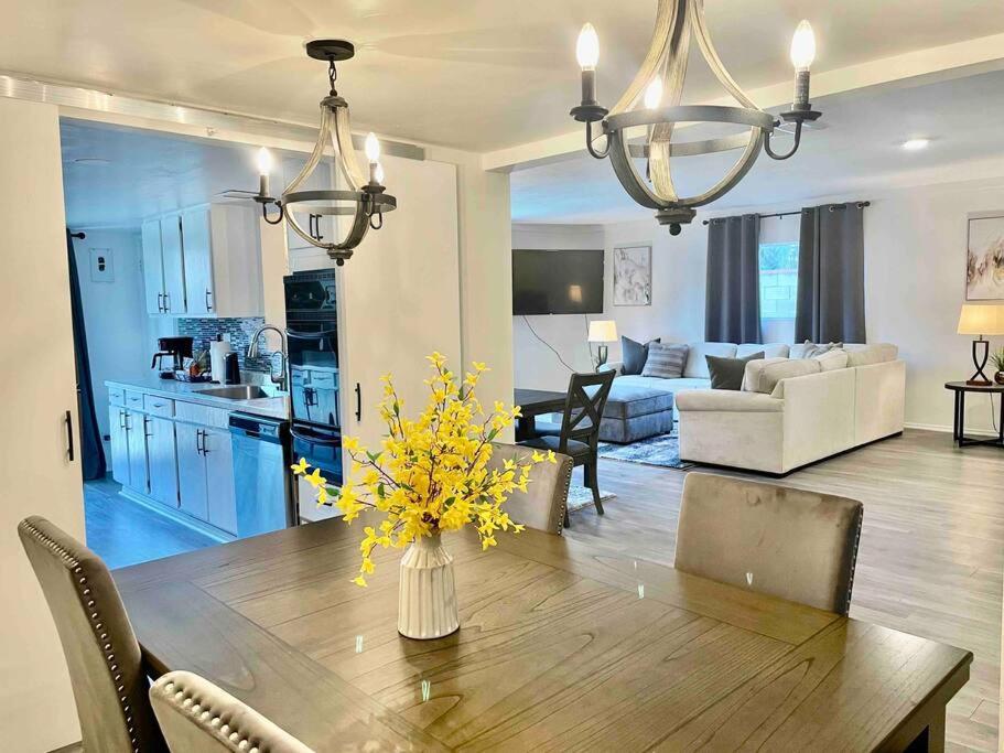 格倫多拉的住宿－Glendora Pool Home Retreat，厨房以及带黄色花卉木桌的起居室。