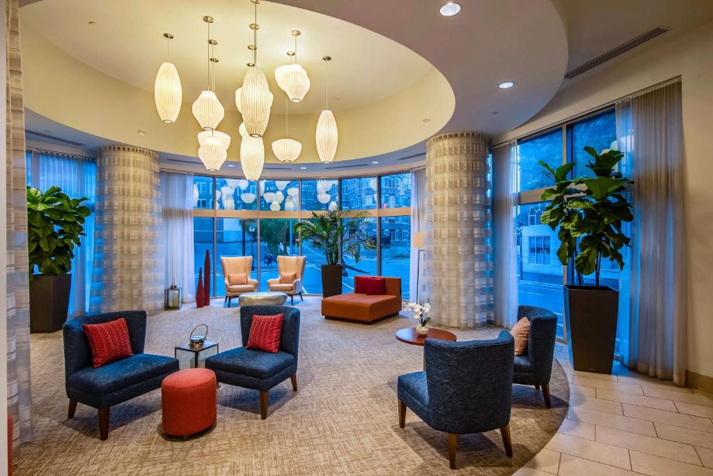 a lobby with chairs and tables and windows at Hilton Garden Inn Alexandria Old Town National Harbor in Alexandria