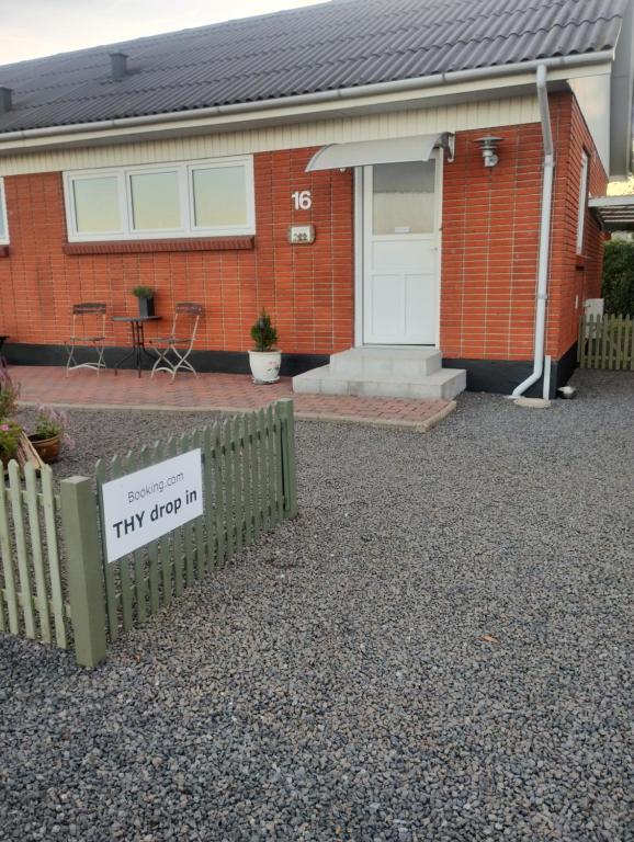 a house with a tiny drop in sign in front of it at Thy drop in in Thisted