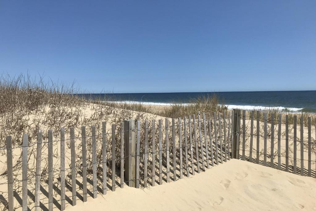 einen Zaun am Strand neben dem Meer in der Unterkunft Montego Bay - Atlantic 13300 in Ocean City