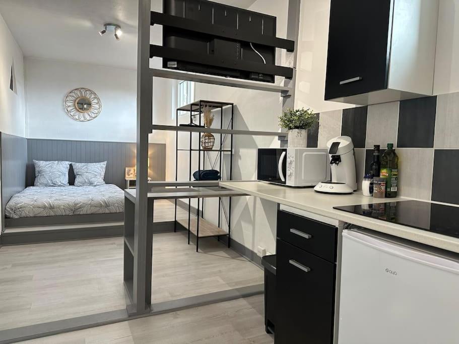 uma cozinha com uma cama num pequeno quarto em Joli studio à 3 min de la Gare em Bourg-en-Bresse