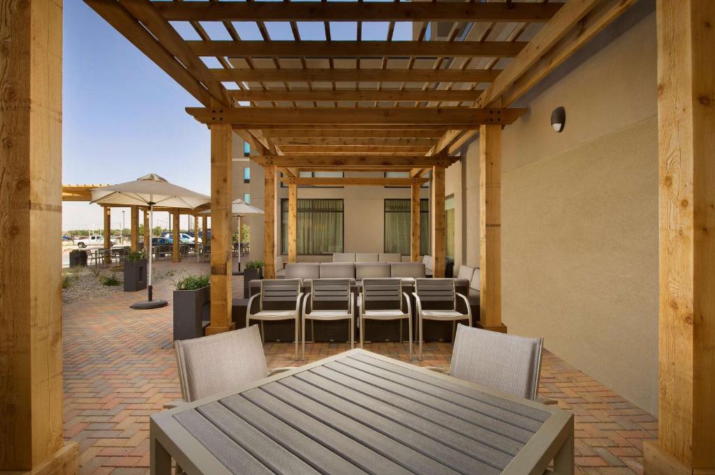 a patio with a table and chairs and an umbrella at Homewood Suites by Hilton Midland in Midland