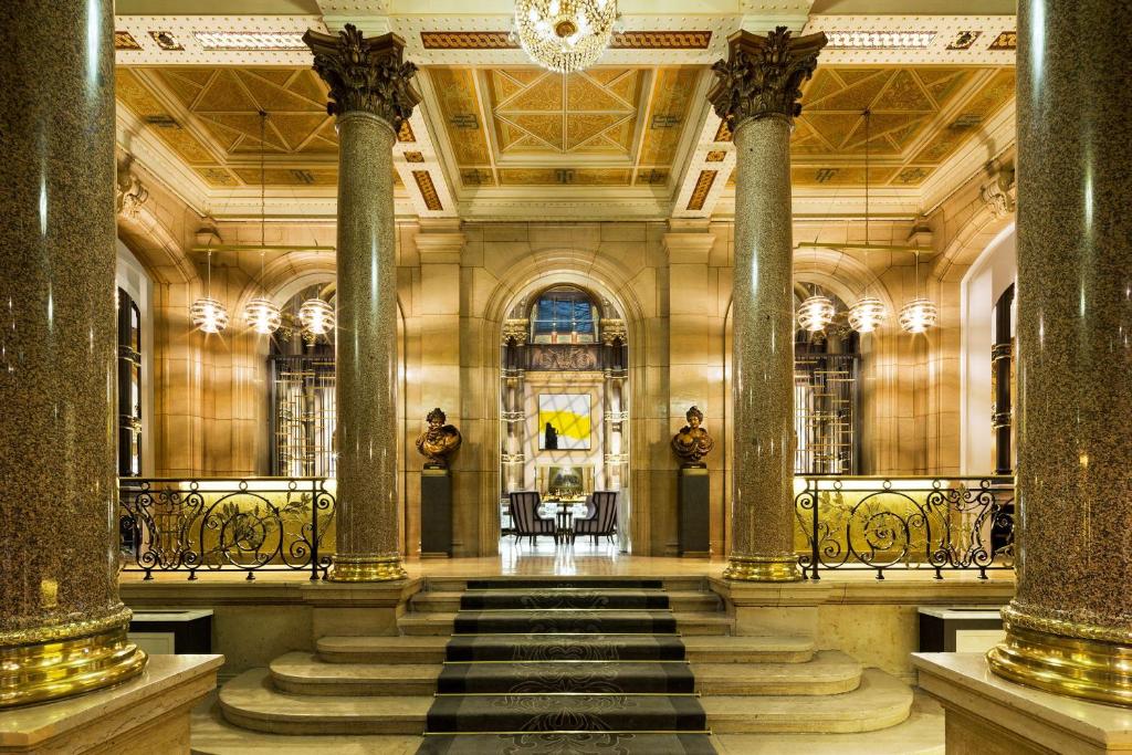 una hall con colonne e una scala in un edificio di Hilton Paris Opera a Parigi