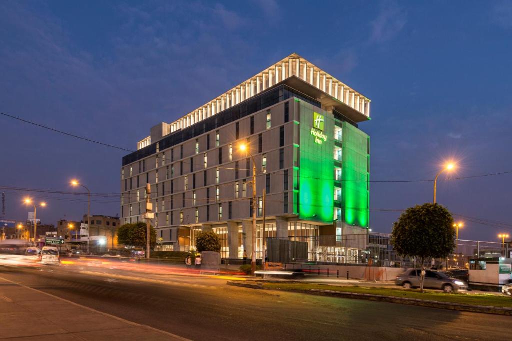 un edificio con una señal verde en el costado. en Holiday Inn - Lima Airport, an IHG Hotel, en Lima