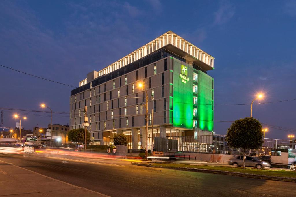 a building with a green sign on the side of it at Holiday Inn - Lima Airport, an IHG Hotel in Lima