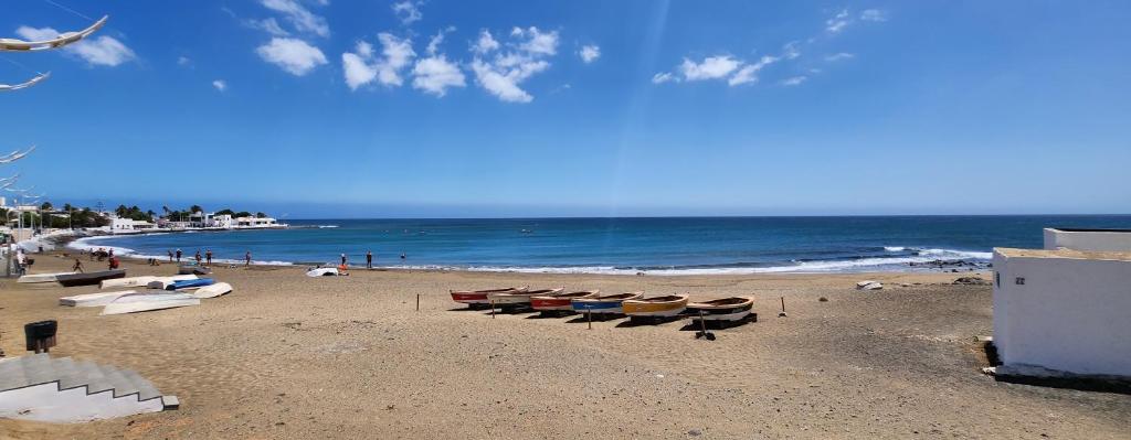 einen Strand mit mehreren Liegestühlen und dem Meer in der Unterkunft Casa Sun & Sea in Playa Honda