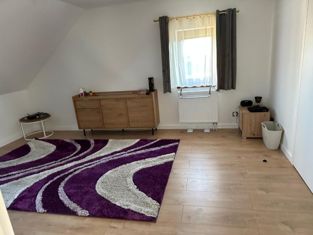 a room with a purple rug on a wooden floor at De lux room 