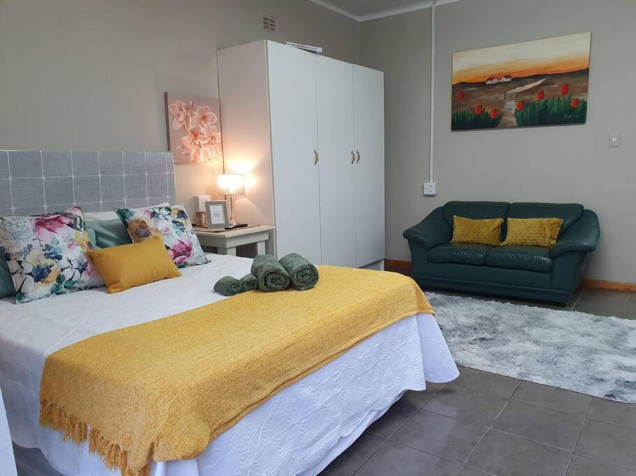 a bedroom with a large bed and a couch at Tree Orchid in Polokwane