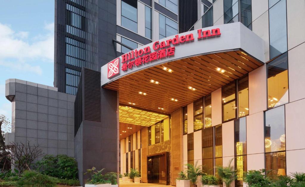 un edificio con un cartel que lee la posada del cáncer interno en Hilton Garden Inn Shenzhen Bao'an en Bao'an