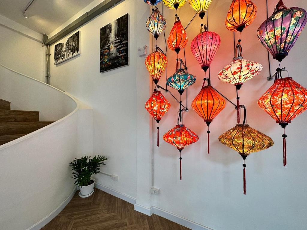 a bunch of colorful lamps hanging on a wall at The White Den Sukhumvit 44 in Bangkok