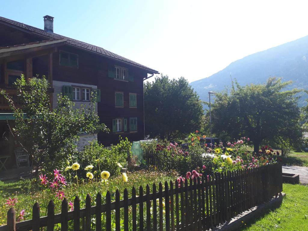 einen Zaun vor einem Haus mit Blumen in der Unterkunft Casa Vegana in Trun