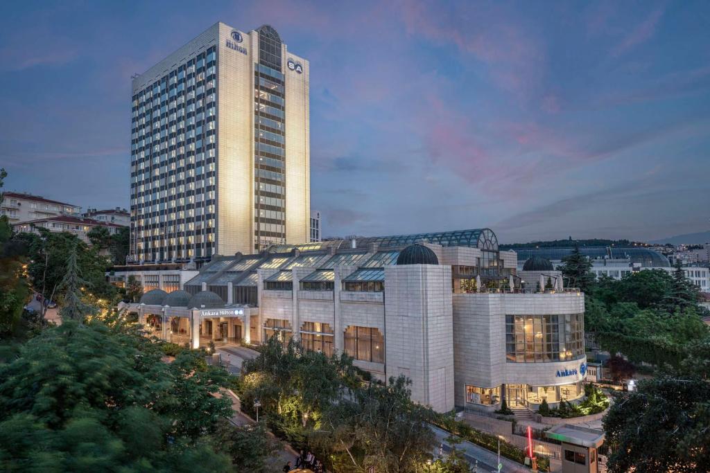 a tall building in front of a city at Ankara HiltonSA in Ankara