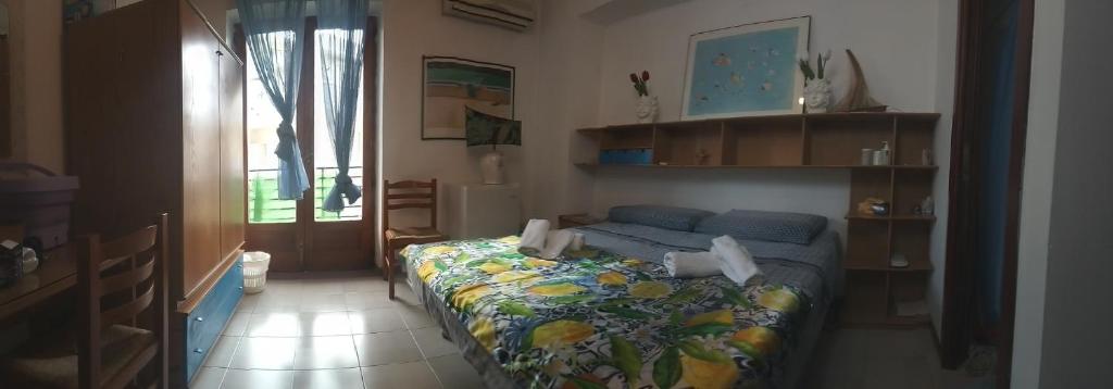 um quarto com uma cama com um cobertor colorido em per noi 2 em Capo dʼOrlando