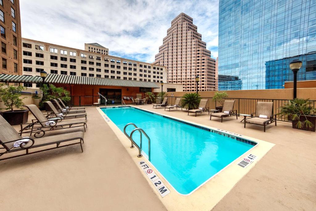 オースティンにあるHampton Inn & Suites Austin-Downtown/Convention Centerの大きなスイミングプール(椅子付)と建物