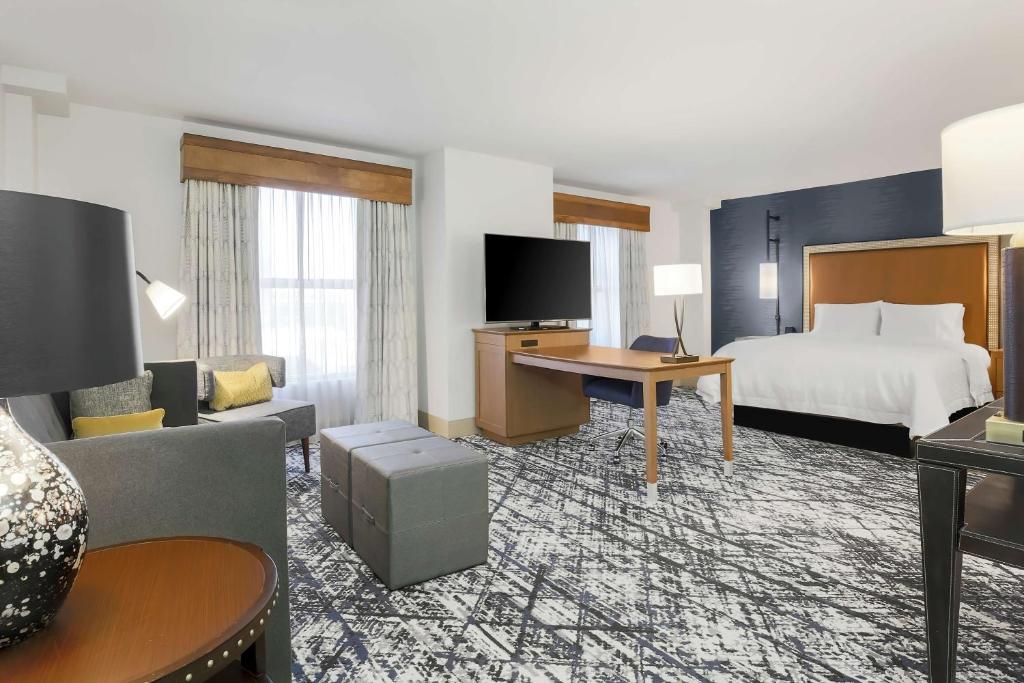 オースティンにあるHampton Inn & Suites Austin-Downtown/Convention Centerのベッドとリビングルームがあるホテルの部屋
