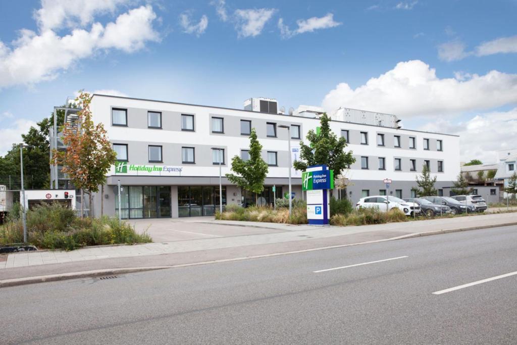 a white building on the side of a street at Holiday Inn Express Munich - Olympiapark, an IHG Hotel in Munich