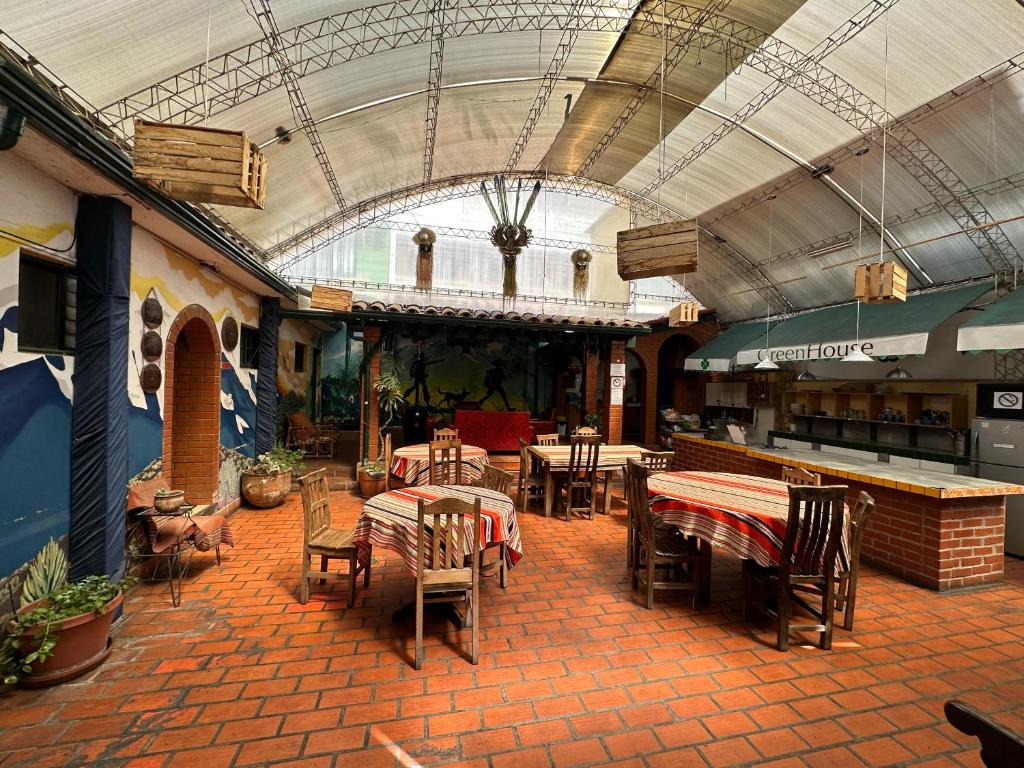 a restaurant with tables and chairs in a building at Greenhouse Bolivia in La Paz