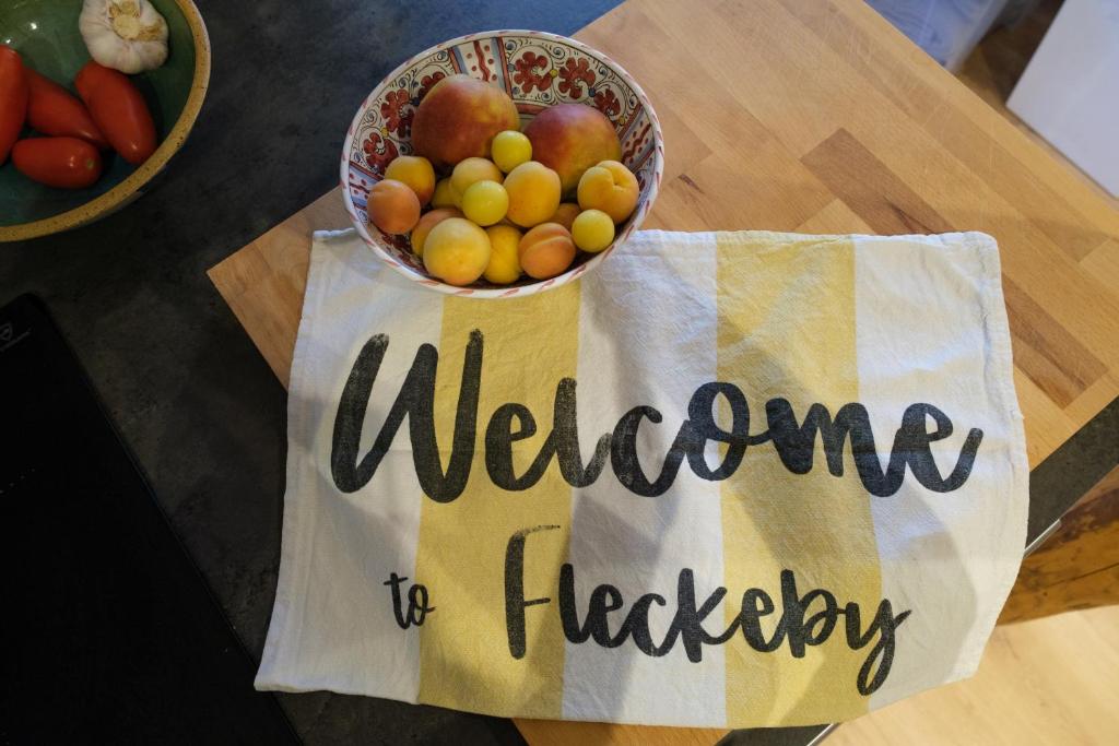 a bowl of fruit on a table with a welcome to friday sign at Lindenhuus in Fleckeby