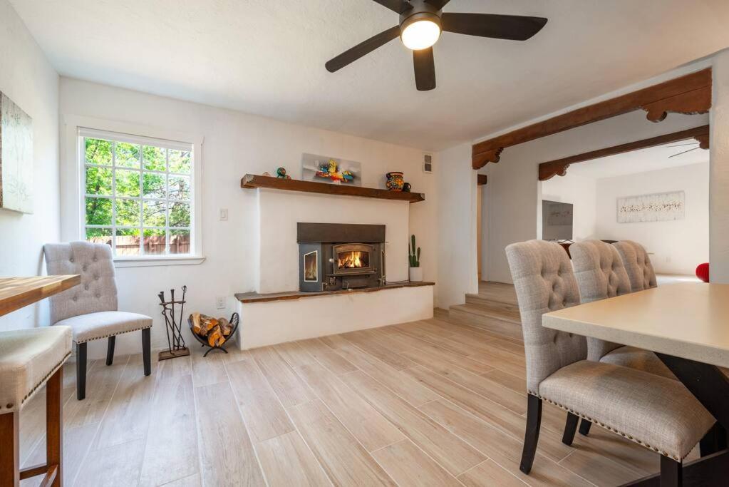 ein Wohnzimmer mit einem Kamin, einem Tisch und Stühlen in der Unterkunft Casa Lupita- Patio & Firepit, King Bed 4BR in Santa Fe