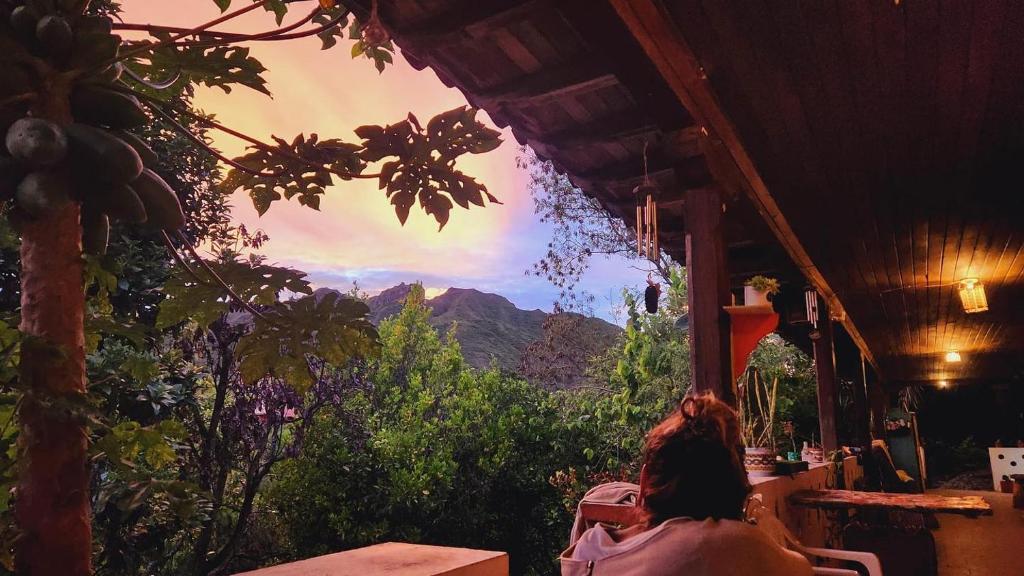 a woman sitting at a table looking out of a window at Matilda Ec in Vilcabamba