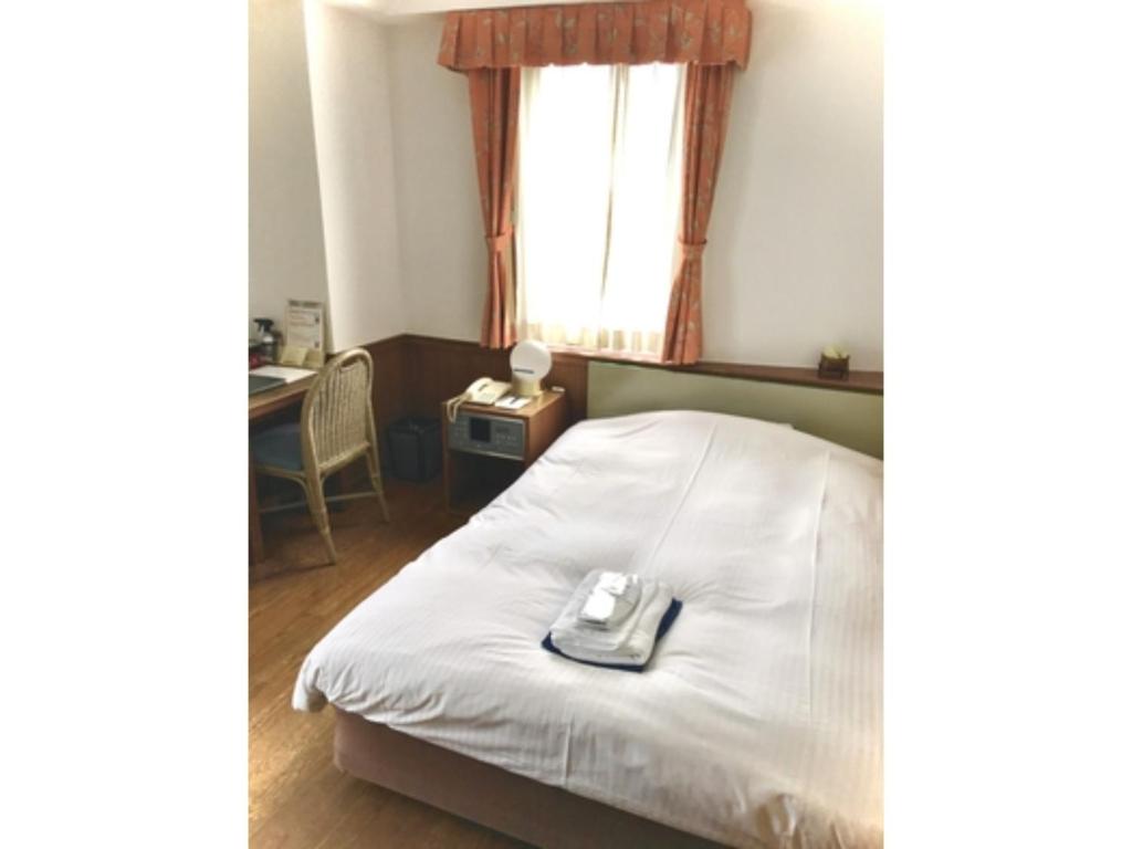 een hotelkamer met een bed met een telefoon erop bij ＨＯＴＥＬ ＰＯＳＨ - Vacation STAY 55598v in Odawara