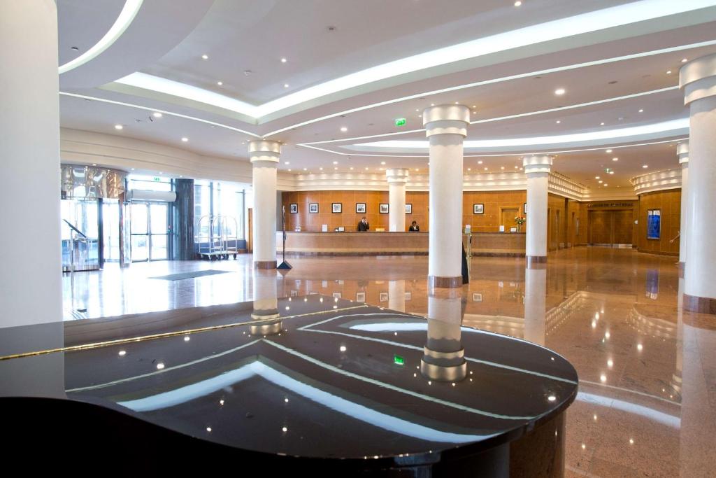 a large lobby with a large hall with columns at Hilton Paris Charles De Gaulle Airport in Roissy-en-France