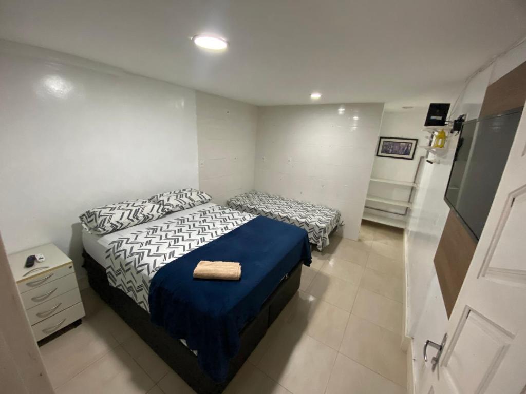 1 dormitorio con 2 camas individuales y nevera en Best House Victoria, en Vitória