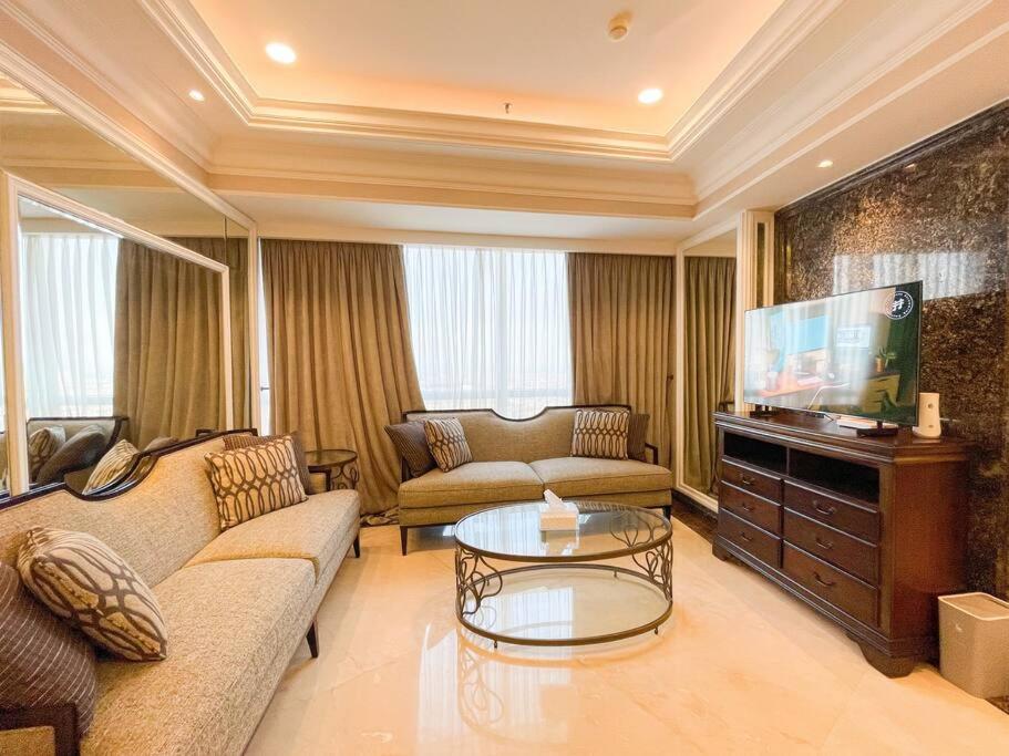 a living room with a couch and a flat screen tv at The Jewel of La Casa III in Surabaya