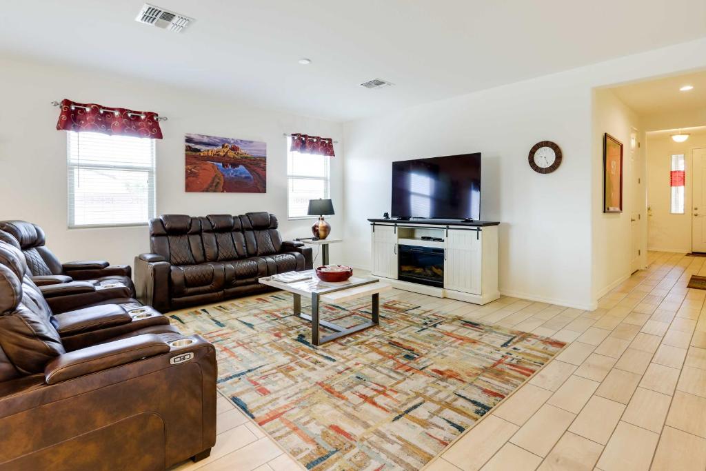 sala de estar con muebles de cuero y TV en 3 Mi to Goodyear Ballpark Desert Den with Pool, en Goodyear