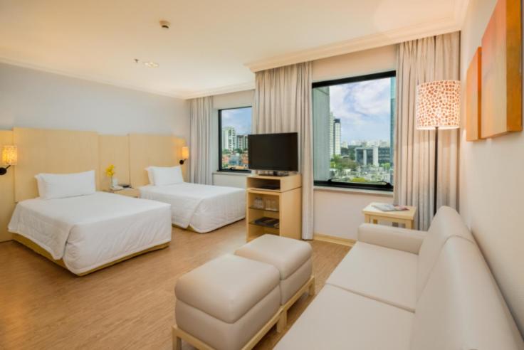 a hotel room with two beds and a couch at Blue Tree Premium Morumbi in Sao Paulo